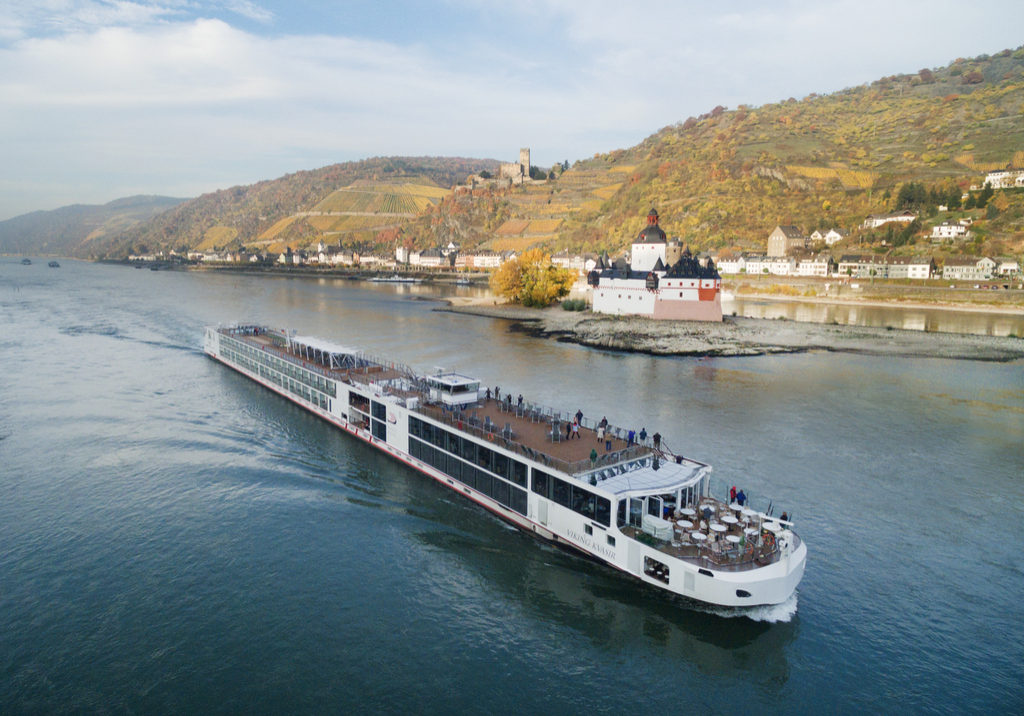 Viking Longship Kvasir along the Rhine River near the town of Kaub with Pfalsgafenstein Castle on the riverbank and Gutenfels Castle above on the hillside.